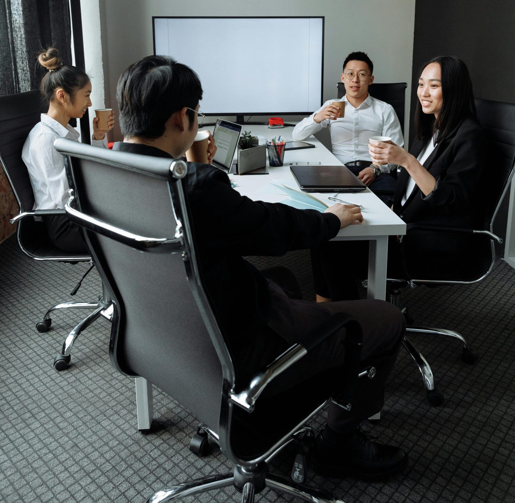 Group of professionals engaged in a collaborative meeting in a modern office setting.