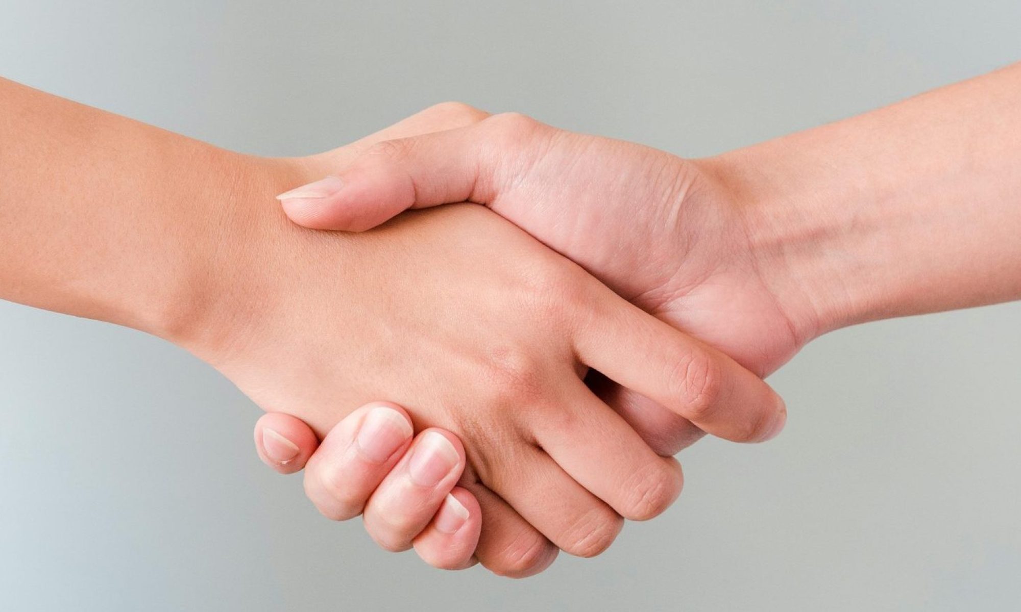 A detailed view of a handshake between two individuals, symbolizing agreement and collaboration.